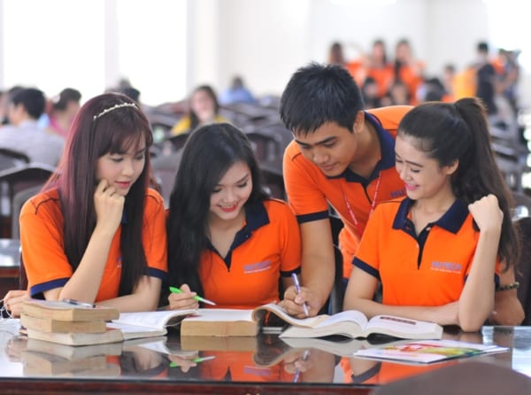 Nhóm sinh viên học nhóm mặc áo thun đồng phục có cổ màu cam