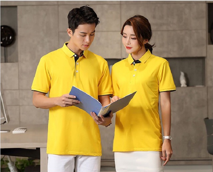 Cặp đôi mặc áo thun đồng phục polo màu vàng xem tài liệu