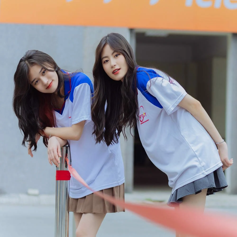 Hai thiếu nữ mặc áo thun đồng phục trường
