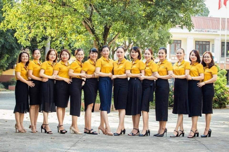 Nhóm phụ nữ mặc áo thun đồng phục màu vàng dàn hàng ngang